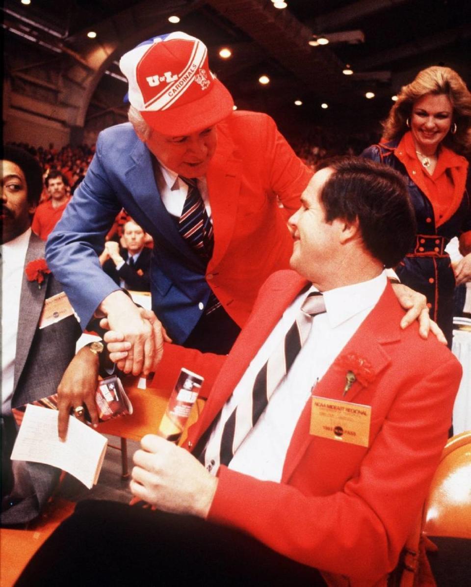 Then-Kentucky Gov. John Y. Brown Jr., wearing a blue and red sport coat and cap representing both the University of Kentucky and the University of Louisville greeted U of L Coach Denny Crum prior to the NCAA Tournament Mideast Regional finals in Knoxville, Tenn., on March 26, 1983. Louisville won the first “Dream Game” between the two state schools, 80-68. At right rear was Brown’s wife, Phyllis George Brown. John Y. Brown died last fall. Phyllis George died in 2020.