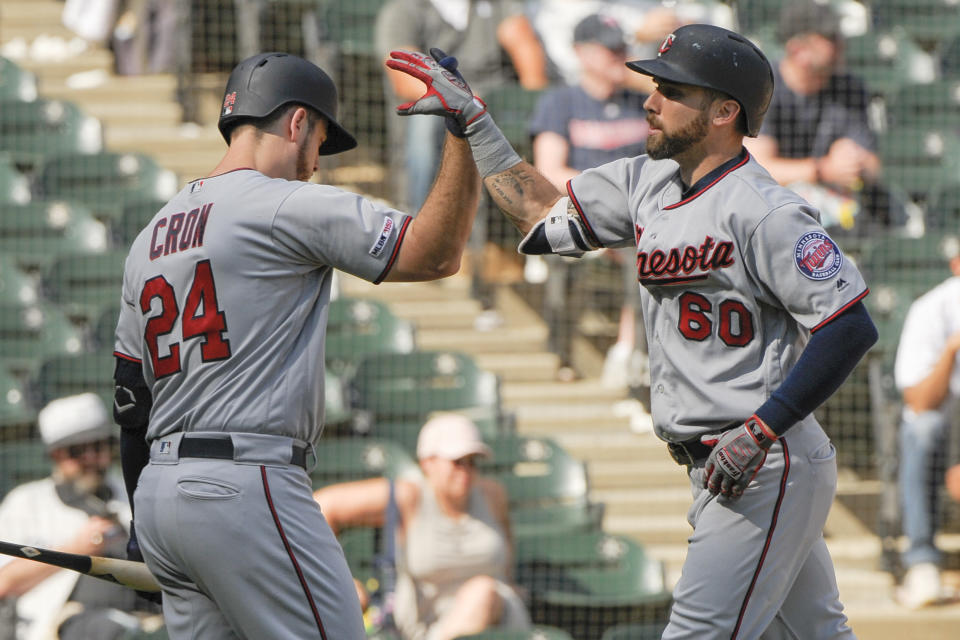 Minnesota Twins' C.J. Cron (24) congratulates Jake Cave (60) on his seventh-inning home run against the Chicago White Sox during a baseball game Thursday, Aug. 29, 2019, in Chicago. (AP Photo/Mark Black)