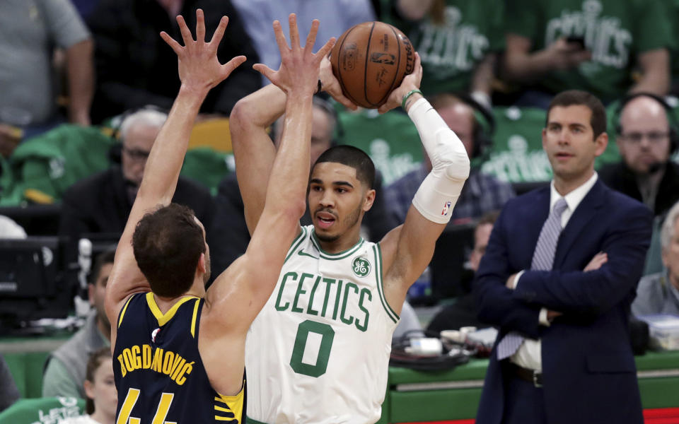 Boston Celtics forward Jayson Tatum (0) looks to pass as he is pressured by Indiana Pacers forward Bojan Bogdanovic (44) during the first quarter of Game 2 of an NBA basketball first-round playoff series, Wednesday, April 17, 2019, in Boston. At right is Boston Celtics head coach Brad Stevens. (AP Photo/Charles Krupa)