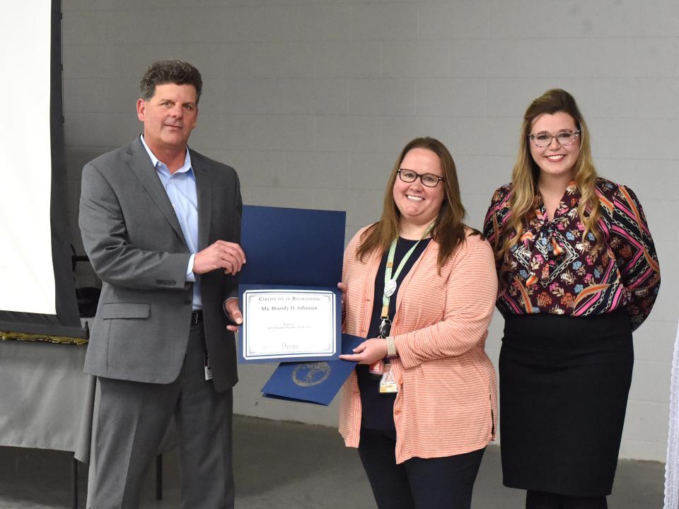 Staunton City Schools Superintendent Garett Smith presents the Region V teacher of the year to Shelburne's Brandy Johnson Monday afternoon. Also present was Virginia's Deputy Secretary of Education, McKenzie Snow.