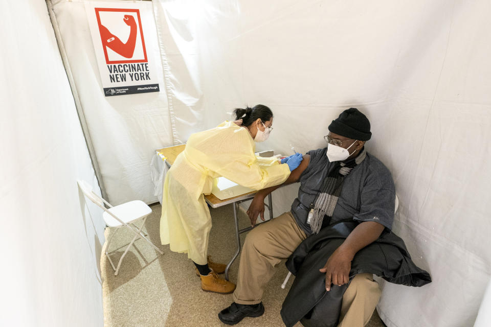 FILE - In this Jan. 23, 2021, file photo, registered Nurse Shyun Lin, left, gives Roberto Fisher, 72, the first dose of the COVID-19 vaccine at a pop-up vaccination site in the William Reid Apartments in the Brooklyn borough of New York. Coronavirus deaths and cases per day in the U.S. dropped markedly over the past couple of weeks but are still running at alarmingly high levels, and the effort to snuff out COVID-19 is becoming an ever more urgent race between the vaccine and the mutating virus. (AP Photo/Mary Altaffer, Pool, File)