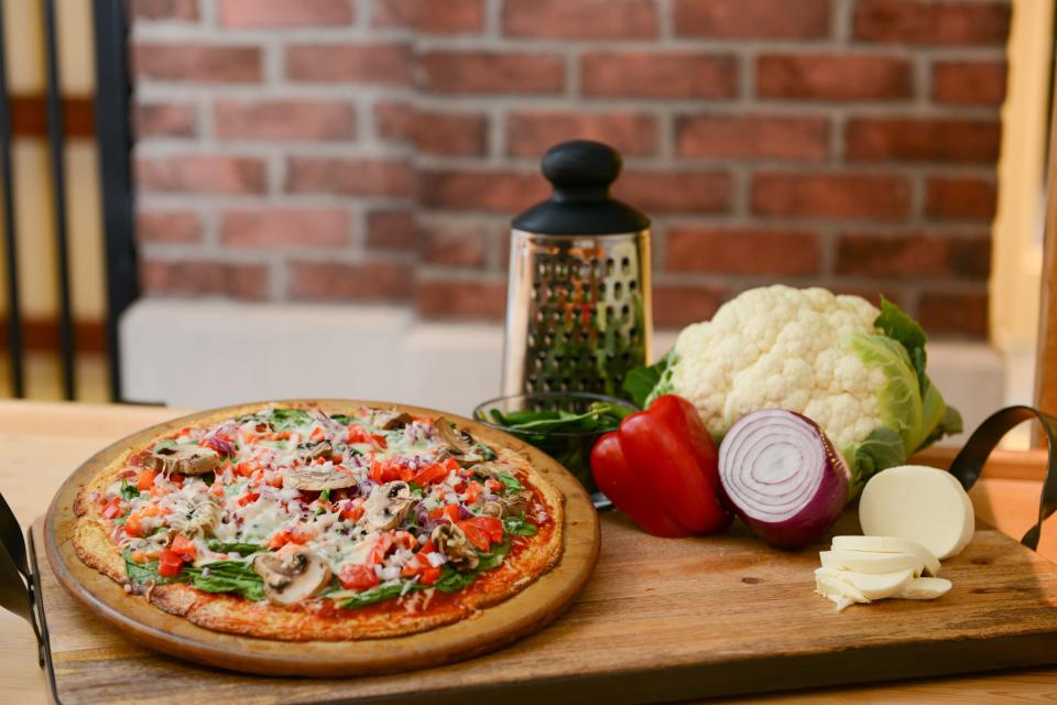 Cauliflower Crust Pizza is topped with spinach, mushrooms and mozzarella.