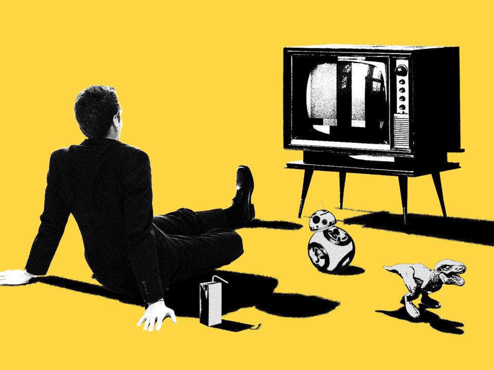 A business man sitting in front of a TV with other nostalgic items around him