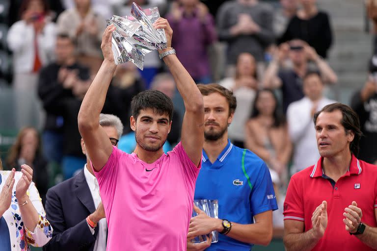 Carlos Alcaraz y el trofeo de campeón de Indian Wells; detrás Daniil Medvedev y el director del torneo, Tommy Haas