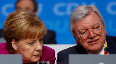 German Chancellor Angela Merkel talks to Volker Bouffier during a Christian Democratic Union (CDU) party congress in Berlin, Germany, February 26, 2018. REUTERS/Fabrizio Bensch