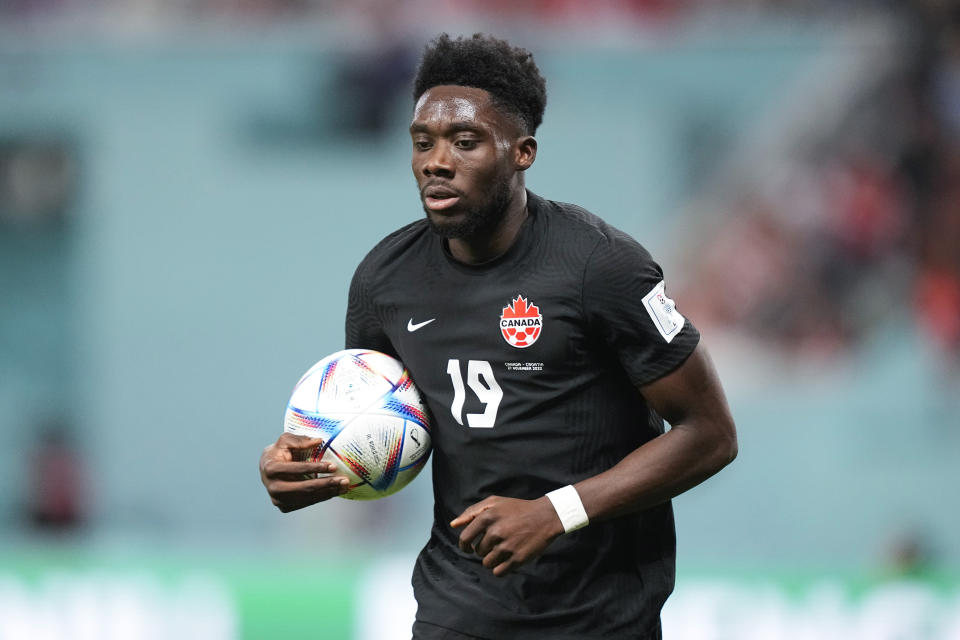 Canada's Alphonso Davies grabs the ball during the World Cup group F soccer match between Croatia and Canada, at the Khalifa International Stadium in Doha, Qatar, Sunday, Nov. 27, 2022. (AP Photo/Martin Meissner)