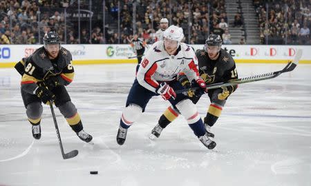 May 30, 2018; Las Vegas, NV, USA; Washington Capitals center Nicklas Backstrom (19) chases the puck between Vegas Golden Knights center Jonathan Marchessault (81) and right wing Reilly Smith (19) in the third period in game two of the 2018 Stanley Cup Final at T-Mobile Arena. Gary A. Vasquez-USA TODAY Sports