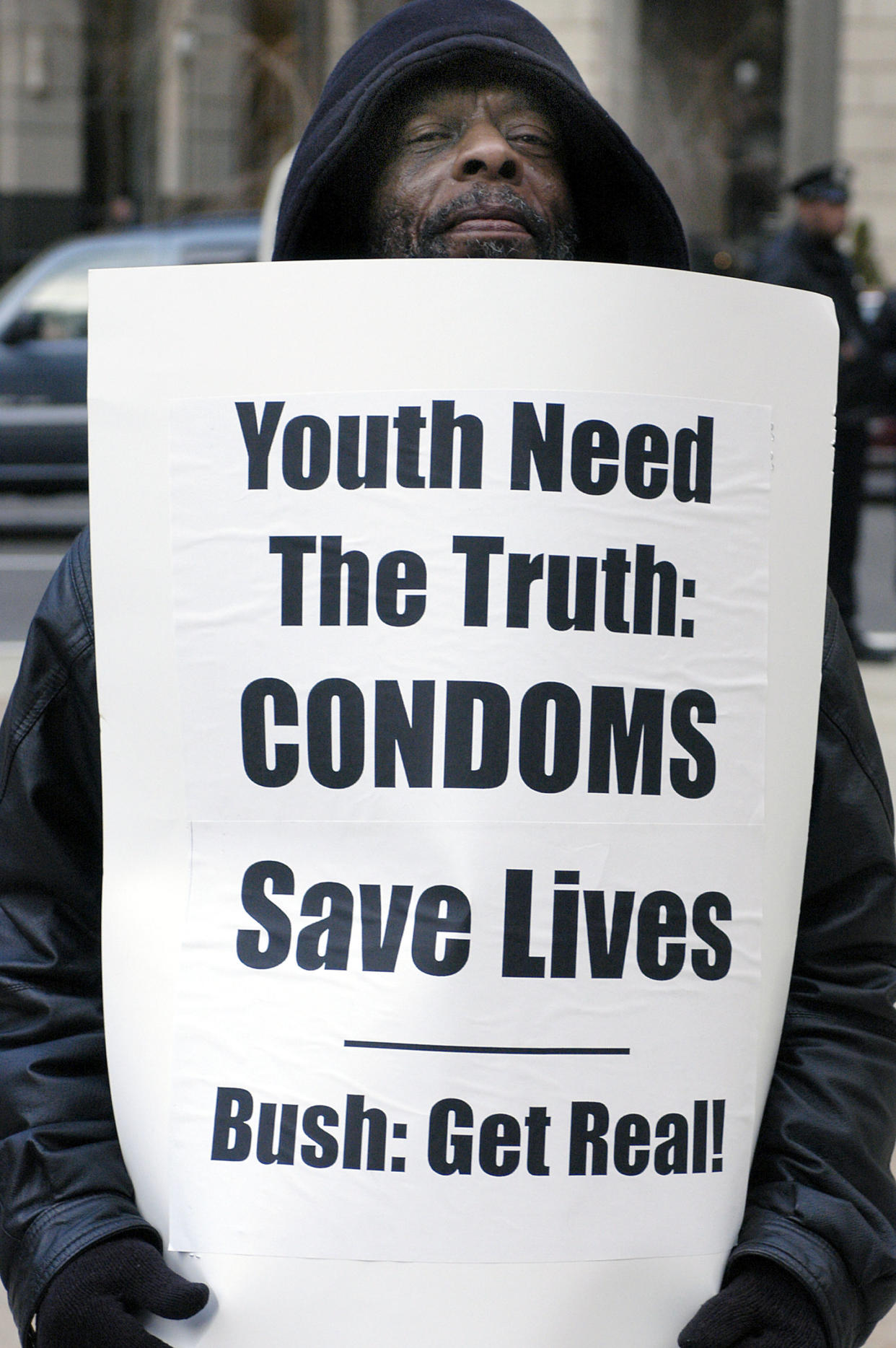 A man holds a protest sign reading: 