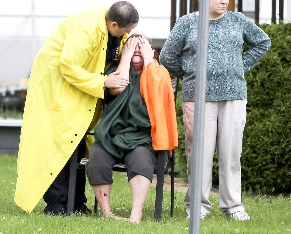 A woman in Proctor, Minn. reacts after the report of a boy was swept away into a sinkhole on Lawn Street in Proctor Wednesday, June 20, 2012. The boy was later found alert and conscious after being swept through six block of culverts by the floodwaters. Record rainfall occurred in the Duluth, Minn., area Wednesday, with some areas receiving seven to 10 inches of rain in the past 24 hours. (AP Photo/The Duluth News-Tribune, Clint Austin)