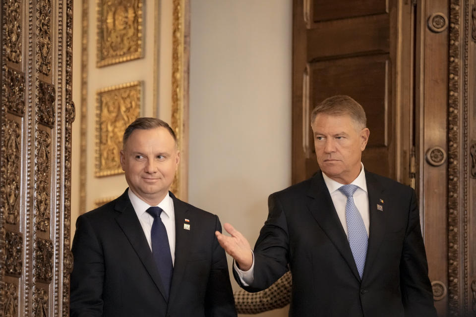 Polish President Andrzej Duda, left, and Romania's President Klaus Iohannis arrive for press statements at the end of the Bucharest Nine (B9) Summit at the Cotroceni Presidential Palace in Bucharest, Romania, Friday, June 10, 2022. (AP Photo/Andreea Alexandru)