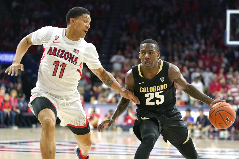 Colorado guard McKinley Wright IV (25) shields the ball from Arizona forward Ira Lee during the first half of an NCAA college basketball game Saturday, Jan. 18, 2020, in Tucson, Ariz. (AP Photo/Rick Scuteri)