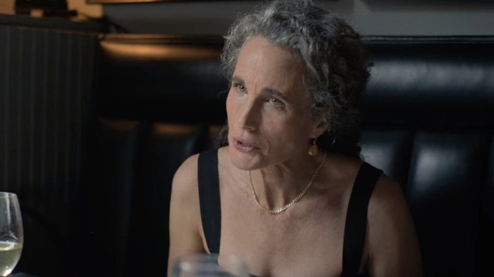 a woman sitting in a booth in mid conversation