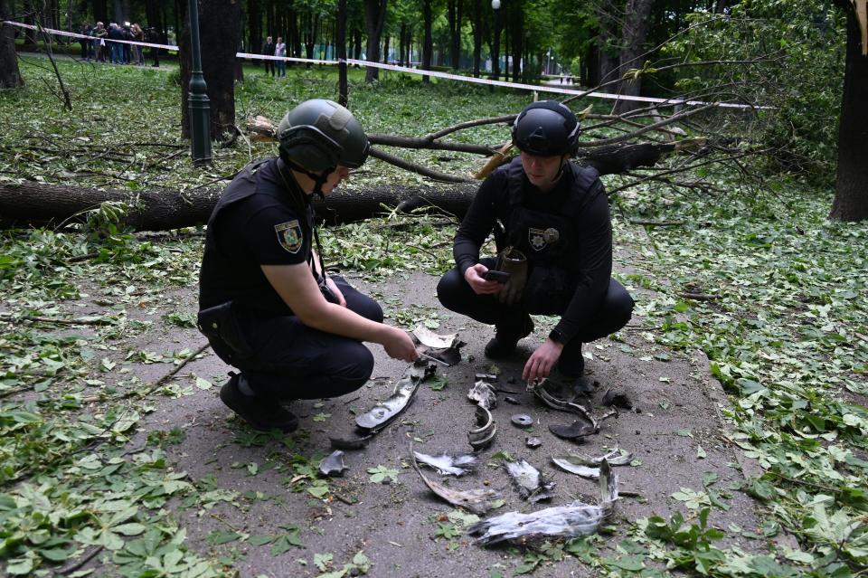 Ukrainian police officers examine fragments of a missile in the central park of Kharkiv (AFP via Getty Images)