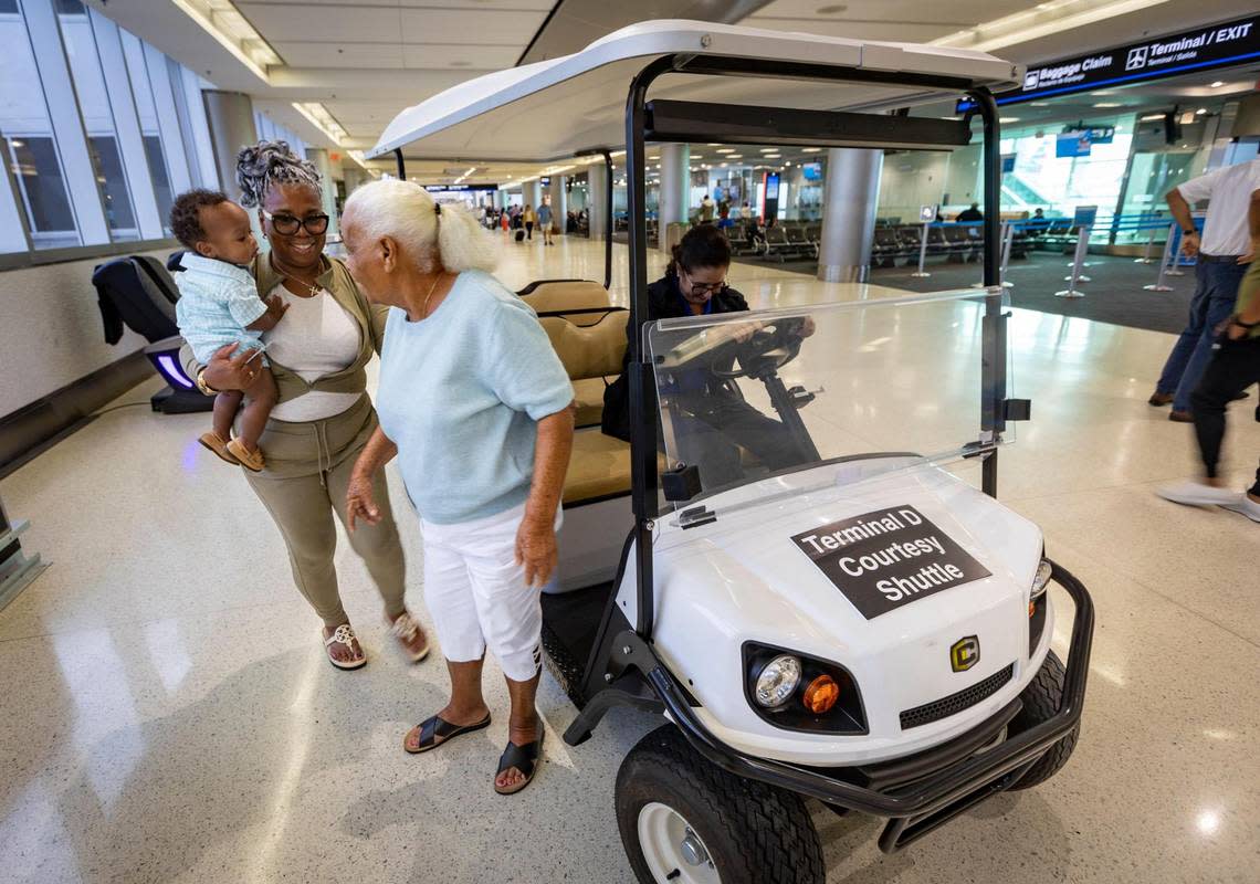 Cynthia Swan, center, and her daughter Jacqueline Brennan, carrying her grandson Luca, are dropped off at their gate by the courtesy shuttle in Concourse D at Miami International Airport on Sept. 27, 2023. With Skytrain shutdown since Sept. 15, shuttles and buses were the only option passengers have had besides walking to get from one end of the terminal to the other.