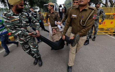  Police detain a demonstrator during a protest against the attack on a bus that killed 44 CRPF personnel in south Kashmir on Thursday - Credit: Reuters