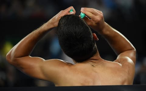 Djokovic applying the eyedrops between sets - Credit: GETTY IMAGES