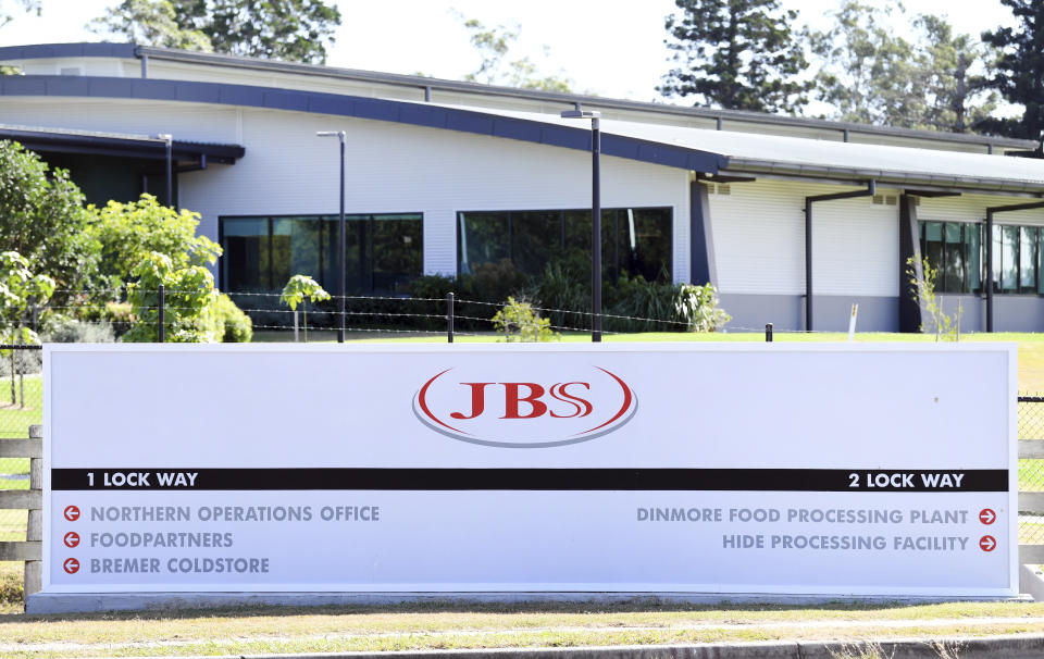 In this May 12, 2020, photo, the company logo sign sits at the entrance to the JBS Australia's Dinmore meatworks facility, west of Brisbane. Thousands of Australian meat workers had no work for a second day on Tuesday, June 1, 2021, after a cyberattack crippled the world’s largest meat processing company. A government minister said it might be days before production resumes. (Dan Peled/AAP Image via AP)