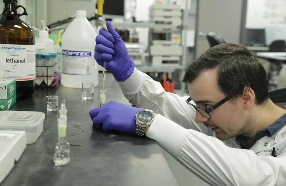 Pierce Prozy prepares a CBD vape oil test sample at Flora Research Laboratories in Grants Pass, Ore., on July 19, 2019. The Associated Press commissioned the lab to test 30 vape products marketed as delivering the cannabis extract CBD. The testing was part of an investigation that shows some people are taking advantage of gaps in federal regulation and law enforcement to exploit booming demand for CBD by substituting cheap and illegal synthetic marijuana for natural CBD. (AP Photo/Ted Warren)