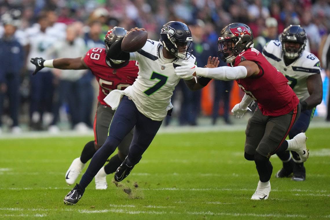 Seattle Seahawks quarterback Geno Smith (7) is sacked by Tampa Bay Buccaneers’ Joe Tryon-Shoyinka (9) during the first half of an NFL football game, Sunday, Nov. 13, 2022, in Munich, Germany. (AP Photo/Matthias Schrader)