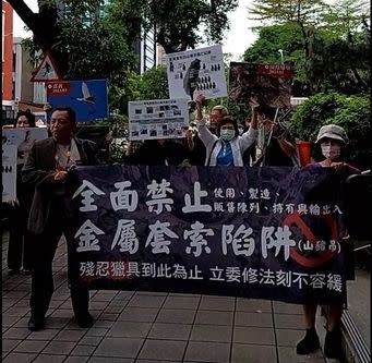 圖片：多個動保團體今天召開「殘忍獵具到此為止，立委修法刻不容緩」記者會，他們先在對街的台大校友會館拉布條，高喊「全面禁止山豬吊．野保法修法刻不容緩」、「禁止使用、製造、販售、陳列、持有與輸出入」等訴求（取自台灣動物共生聯盟臉書影片）