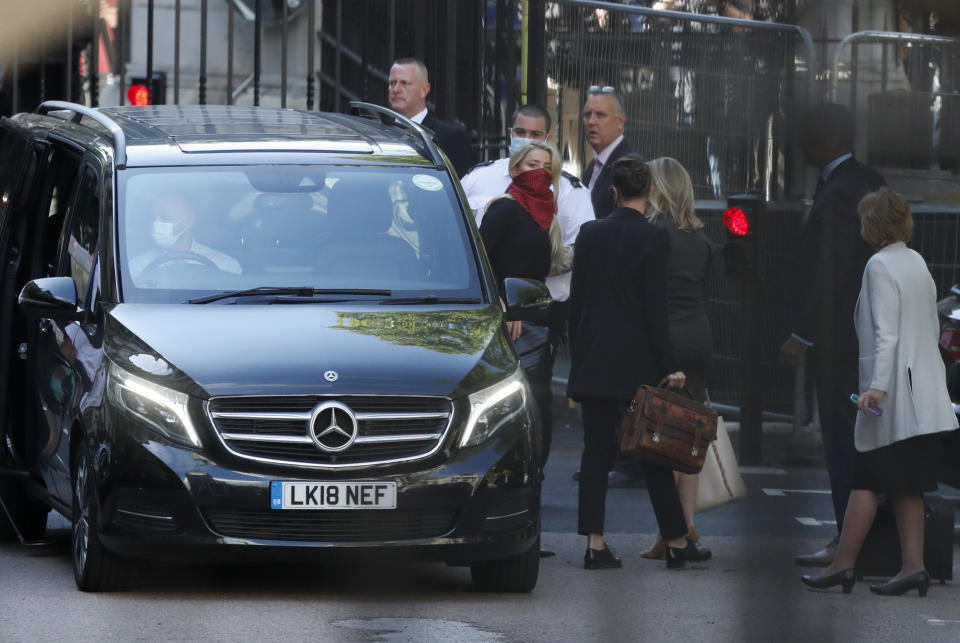 Actress Amber Heard, in red face mask at center, arrives at the High Court in London, Tuesday, July 7, 2020. Johnny Depp has a starring role in a real-life courtroom drama in London, where he is suing a tabloid newspaper for libel over an article that branded him a "wife beater." On Tuesday, a judge at the High Court is due to begin hearing Depp's claim against The Sun's publisher, News Group Newspapers, and its executive editor, Dan Wootton, over the 2018 story alleging he was violent and abusive to then-wife Amber Heard. Depp strongly denies the claim. (AP Photo/Alastair Grant)