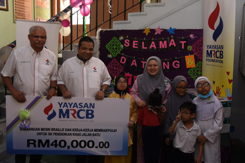 (From left) Yayasan MRCB trustees Dr Mohamed Rafick Khan and Datuk Shamrat Sen Gupta presenting a cheque worth RM40,000 to the school principal Puan Norzimah. — Picture courtesy of Yayasan MRCB