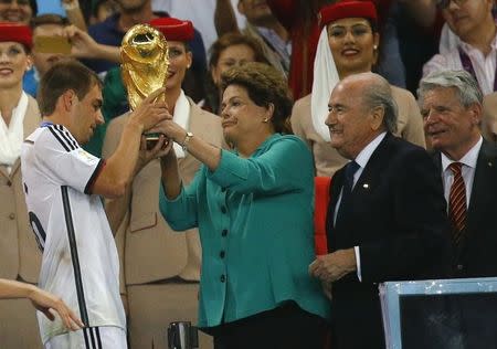 Brazil's President Dilma Rousseff (2nd L), FIFA President Sepp Blatter (2nd R) and German President Joachim Gauck (R) watch as Germany's Philipp Lahm lifts the World Cup trophy after winning the 2014 World Cup final against Argentina at the Maracana stadium in Rio de Janeiro July 13, 2014. REUTERS/Kai Pfaffenbach