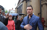 Carl Pistorius, right, the brother of Oscar Pistorius walks outside the high court before the start of his brother's trial in Pretoria, South Africa, Monday, March 3, 2014. Pistorius is charged with murder with premeditation in the shooting death of girlfriend Reeva Steenkamp in the pre-dawn hours of Valentine's Day 2013. (AP Photo/Schalk van Zuydam)