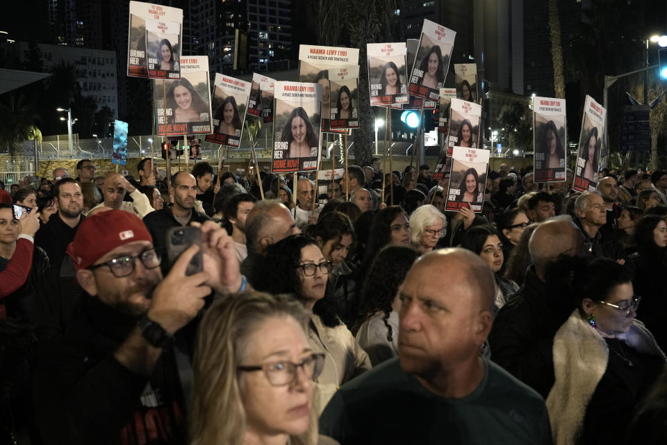 People hold signs showing a picture of a hostage during a demonstration calling for the release of the hostages taken by Hamas militants to Gaza during the Oct. 7th attack, during a demonstration in Tel Aviv, Israel, Saturday Jan. 20, 2024. (AP Photo/Leo Correa)