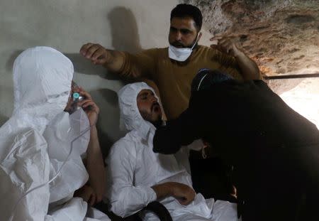 FILE PHOTO: A man breathes through an oxygen mask as another one receives treatments, after what rescue workers described as a suspected gas attack in the town of Khan Sheikhoun in rebel-held Idlib, Syria April 4, 2017. REUTERS/Ammar Abdullah/File Photo