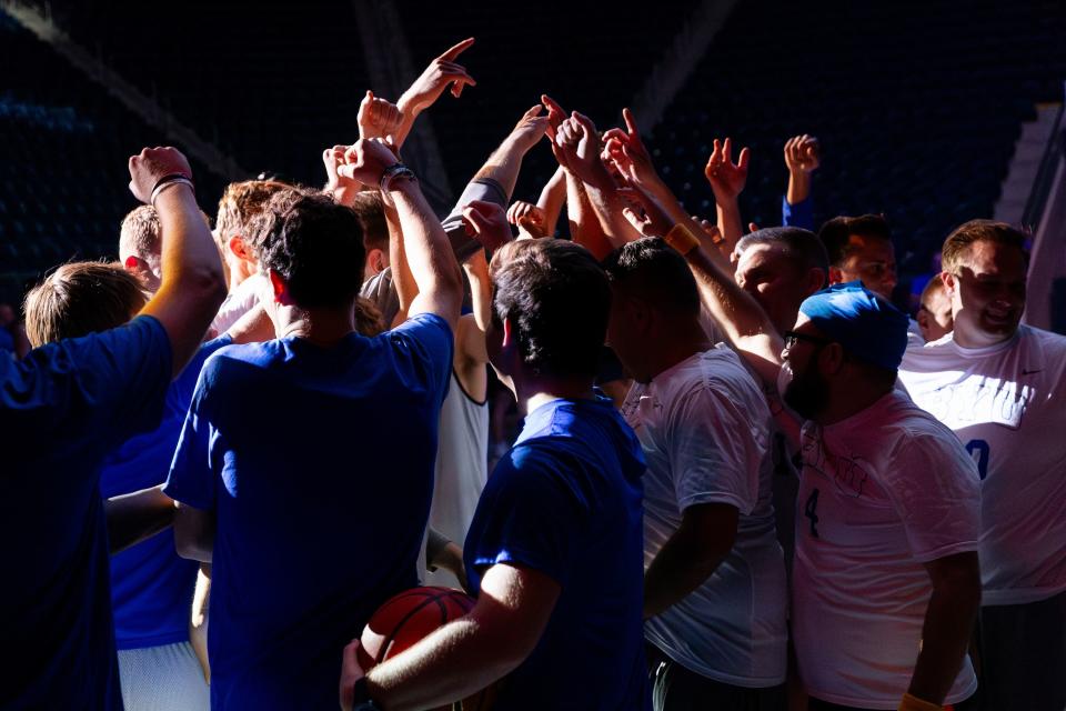 Members of the media, BYU basketball players and members of the BYU coaching staff circle up before playing a basketball game at Media Madness, an event hosted by BYU program, at the Marriott Center in Provo on Monday, Oct. 9, 2023. | Megan Nielsen, Deseret News