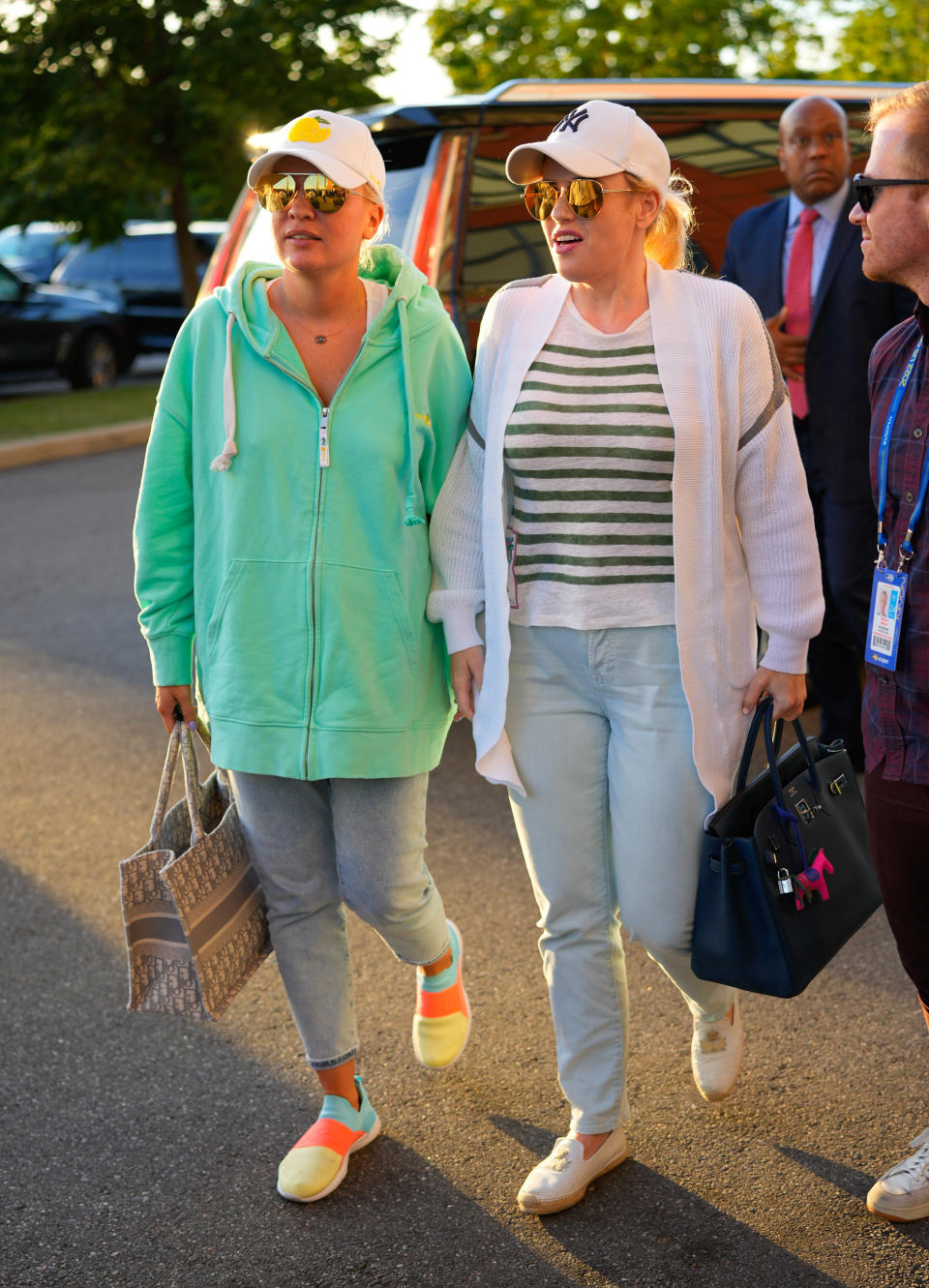 The couple walking outside in casual wear and baseball caps