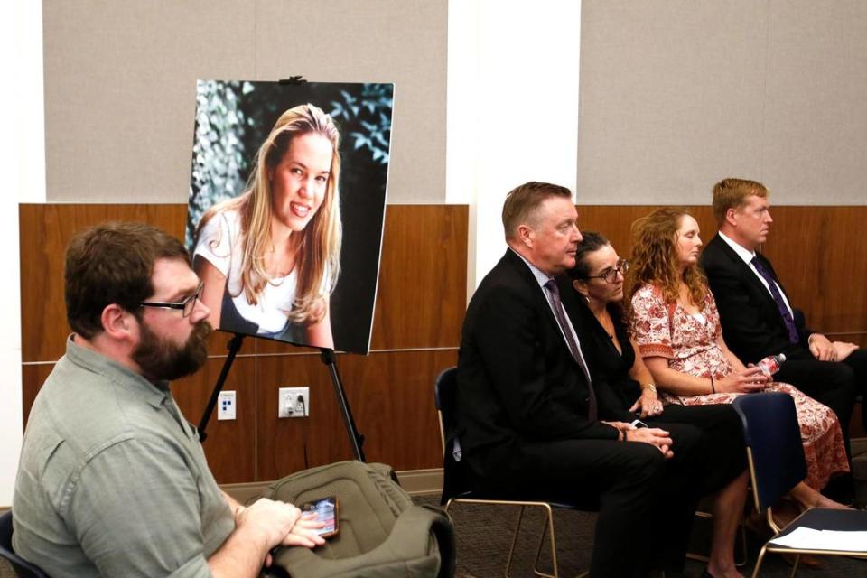 “Your Own Backyard” podcaster Chris Lambert sits in front of a poster of Kristin Smart with family members nearby on Oct. 18, 2022, the day a jury found Paul Flores guilty of murder in Smart’s 1996 disappearance at Cal Poly.