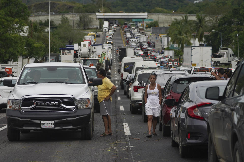 FILE - People wait outside their cars as they wait for repair crews to clear the roads after Hurricane Otis ripped through Acapulco, Mexico, Wednesday, Oct. 25, 2023. Hurricane Otis turned from mild to monster in record time, and scientists are struggling to figure out how — and why they didn't see it coming. (AP Photo/Marco Ugarte, File)