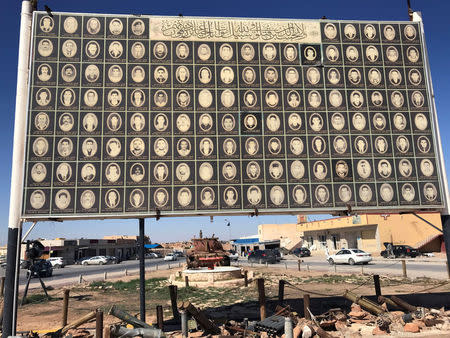 A plaque shows pictures of people who were killed during the 2011 uprising and afterwards, in the city of Bani Walid, Libya October 29, 2017. REUTERS/Ulf Laessing