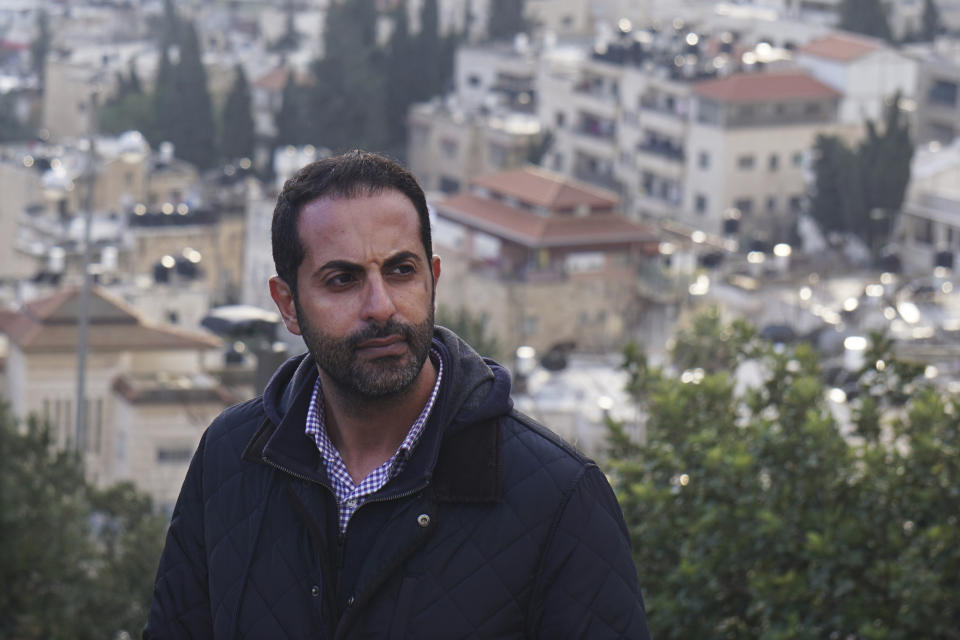 Lawyer Alaa Mahajna poses for a photo on Mount Scopus, overlooking Jerusalem, on Saturday, Feb. 9, 2019. Mahajna was one of at least half a dozen people targeted by a mysterious group of undercover operatives over the past couple of months. All of them have crossed paths, in some way, with the NSO Group, a spyware maker that Mahajna is suing in Israeli court. (AP Photo/Raphael Satter)