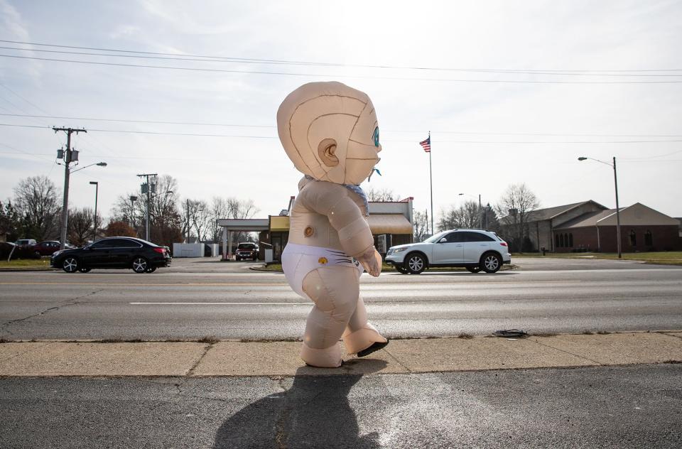 To waves and the sounds of honks, Matthew Peiffer, known as Muncie's Smile Man, makes his way down McGalliard Road.