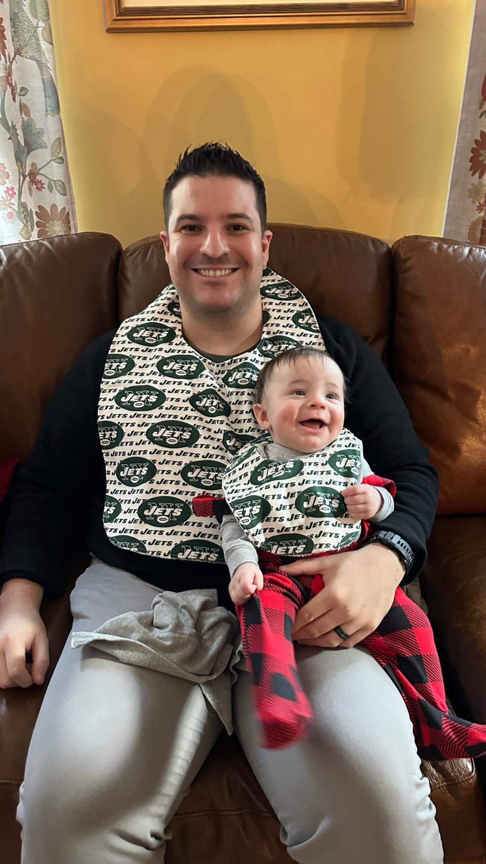 Remy (right) takes in his first Christmas with matching bibs with dad, Joe Rivera.