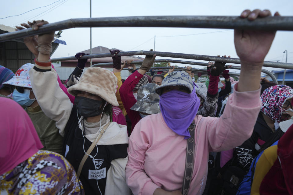 Cambodian garment workers stand on a back truck as they wearing scarfs and caps to protect from the hot sun during return home after a day's working at garment factory outside Phnom Penh Cambodia, Monday, April 29, 2024. Southeast Asia was coping with a weeks long heat wave on Monday as record-high temperatures led to school closings in several countries and urgent health warnings throughout the region. (AP Photo/Heng Sinith)