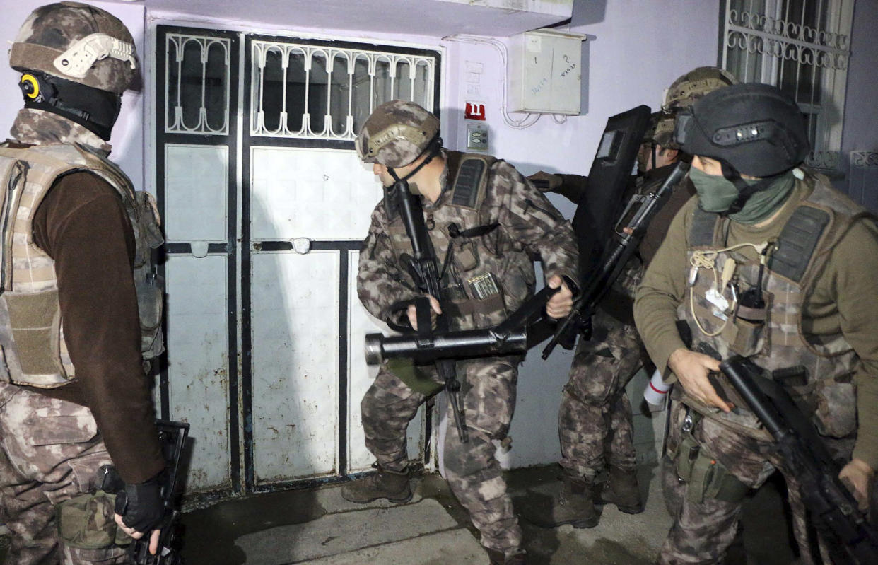 Turkish anti-terrorism police break a door during an operation to arrest people over alleged links to Isis in Adiyaman, southeastern Turkey, during which more than 400 suspects were detained: AP/Mahir Alan/Dha-Depo