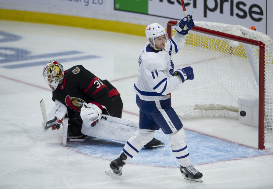 Toronto Maple Leafs left wing Zach Hyman celebrates a goal by teammate Mitchell Marner as Ottawa Senators goaltender Matt Murray looks on during the second period of an NHL hockey game in Ottawa, Ontario, Saturday, Jan. 16, 2021. (Adrian Wyld/The Canadian Press via AP)