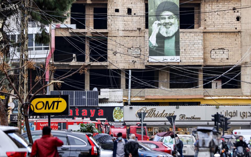 A picture depicting Hassan Nasrallah, the leader of the Lebanese Shiite movement Hezbollah, hangs on a building near the site of a suspected Israeli strike