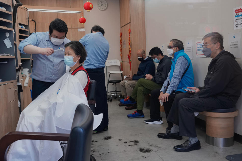 A customer gets haircut at a salon after temporarily closing in Hong Kong, Thursday, March 10, 2022. (AP Photo/Vincent Yu)