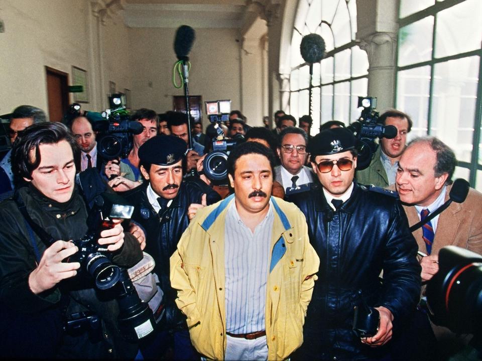 Libyan Khalifa Fhimah (C) escorted by security officers and journalists before appearing at the Supreme court for a hearing in connection with the 1988 december bombing of a Pan Am fligh