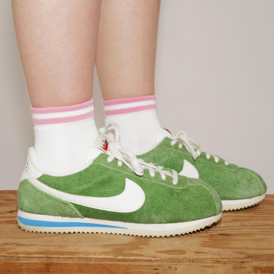 Footwear News Shop editor Olivia Cigliano wears pink striped Bombas socks with green sneakers