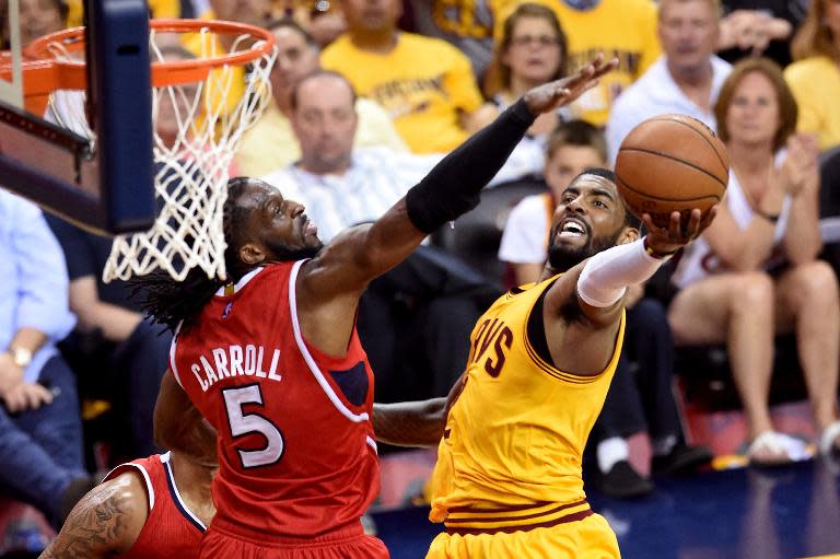 Kyrie Irving (R) of the Cleveland Cavaliers drives to the basket against DeMarre Carroll of the Atlanta Hawks, during Game Four of their NBA Eastern Conference finals, at Quicken Loans Arena in Cleveland, Ohio, on May 26, 2015