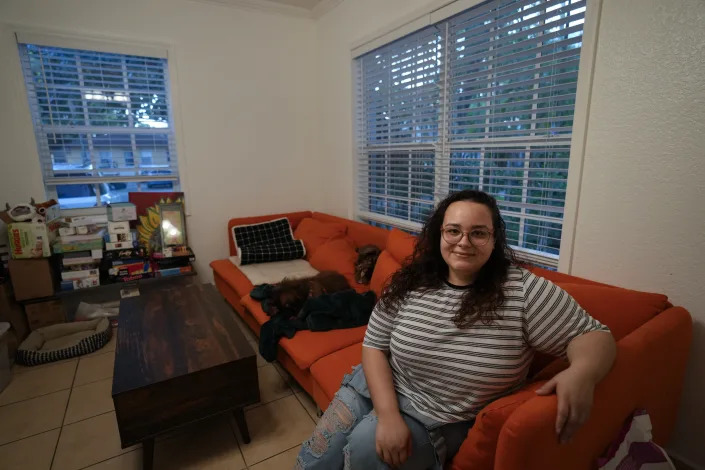 Krystal Guerra, 32, poses for a picture inside her apartment, which she is in the process of packing up to leave after her new landlord gave her less than a month's notice that her rent would go up by 26%, Saturday, Feb. 12, 2022, in the Coral Way neighborhood of Miami. Guerra, who works in marketing while also pursuing a degree part-time, had already been spending nearly 50% of her monthly income on rent prior to the increase. Unable to afford a comparable apartment in the area as rents throughout the city have risen dramatically, Guerra is putting many of her belongings into storage and moving in with her boyfriend and his daughter for the time being. (AP Photo/Rebecca Blackwell)