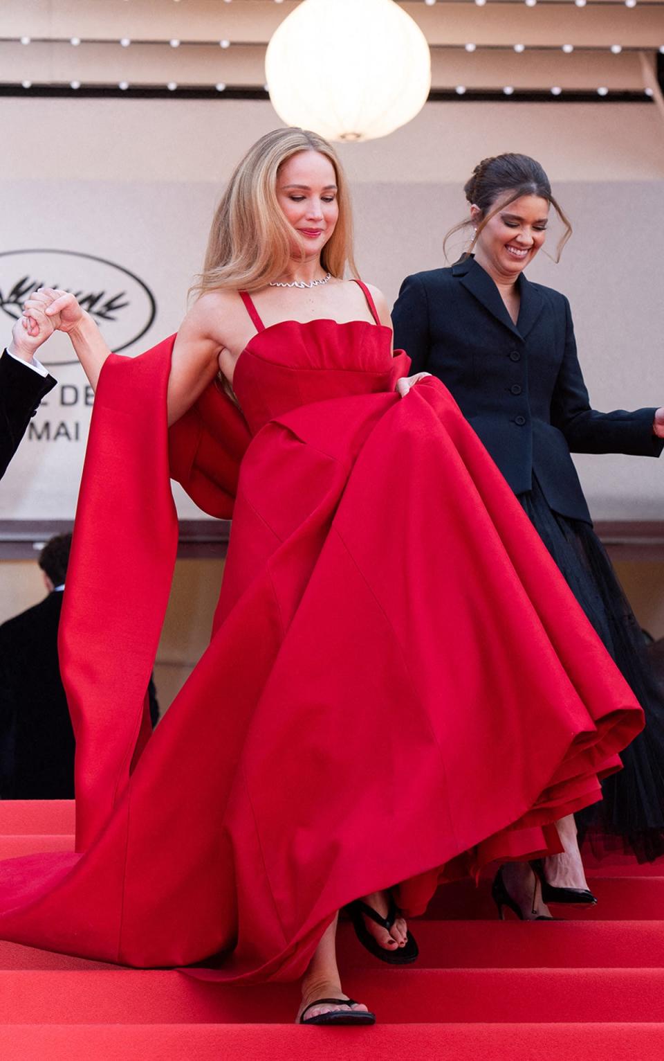 Jennifer Lawrence sports flip-flops beneath her Dior dress on the Cannes red carpet (Marechal Aurore/ABACA/Shutterstock)