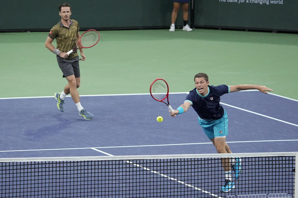 Neal Skupski, of Britain, right, returns a shot in front of teammate Wesley Koolhof, of the Netherlands, during the men's doubles final against Rohan Bopanna, of India, and Matthew Ebden, of Australia, at the BNP Paribas Open tennis tournament Saturday, March 18, 2023, in Indian Wells, Calif. (AP Photo/Mark J. Terrill)