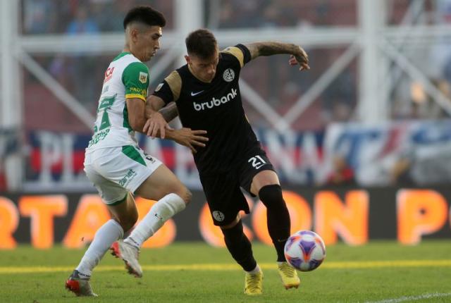 Santiago Solari intenta frenar el avance de Malcom Braida; San Lorenzo y Defensa y Justicia empataron sin goles
